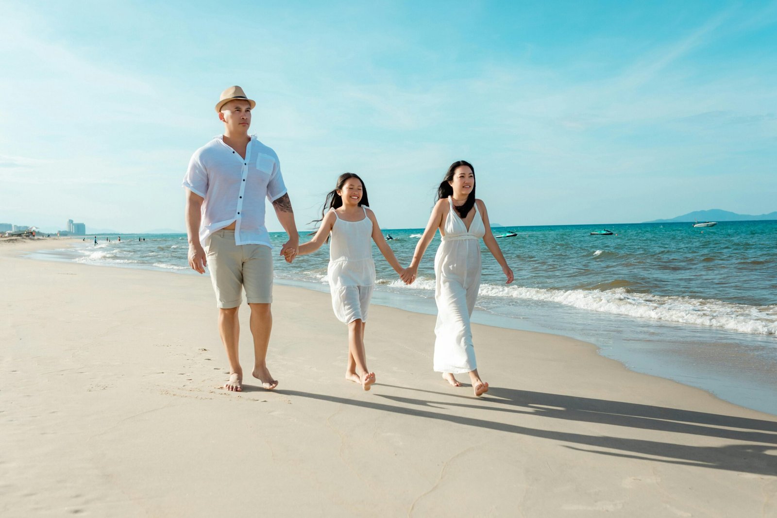 Gezin wandelt langs het strand op een zonnige vakantiedag