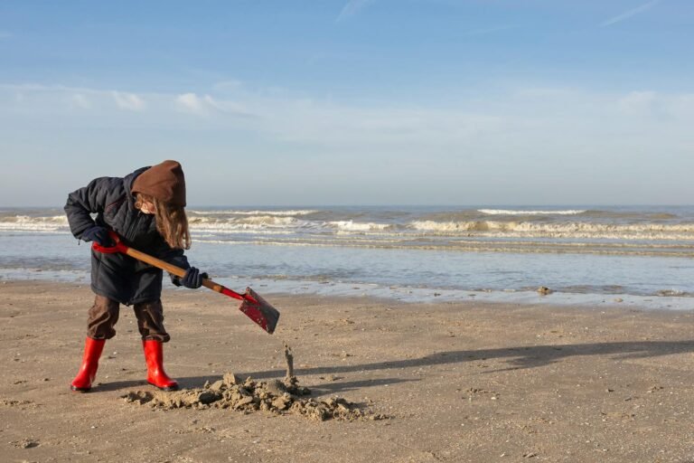 Kind speelt met een schepje op het Zeeuwse strand bij Roompot Beach Resort Nieuwvliet-Bad
