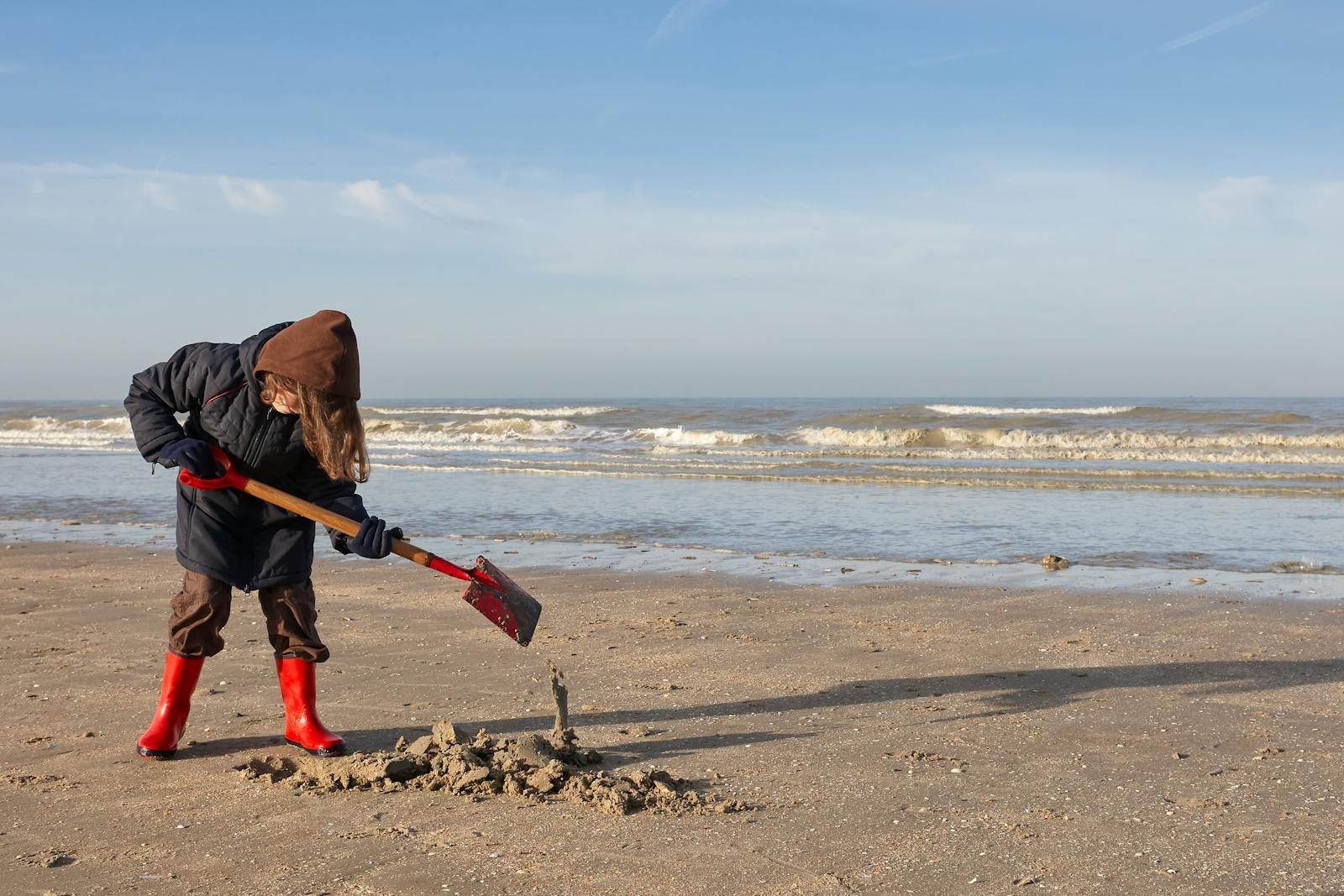 Kind speelt met een schepje op het Zeeuwse strand bij Roompot Beach Resort Nieuwvliet-Bad