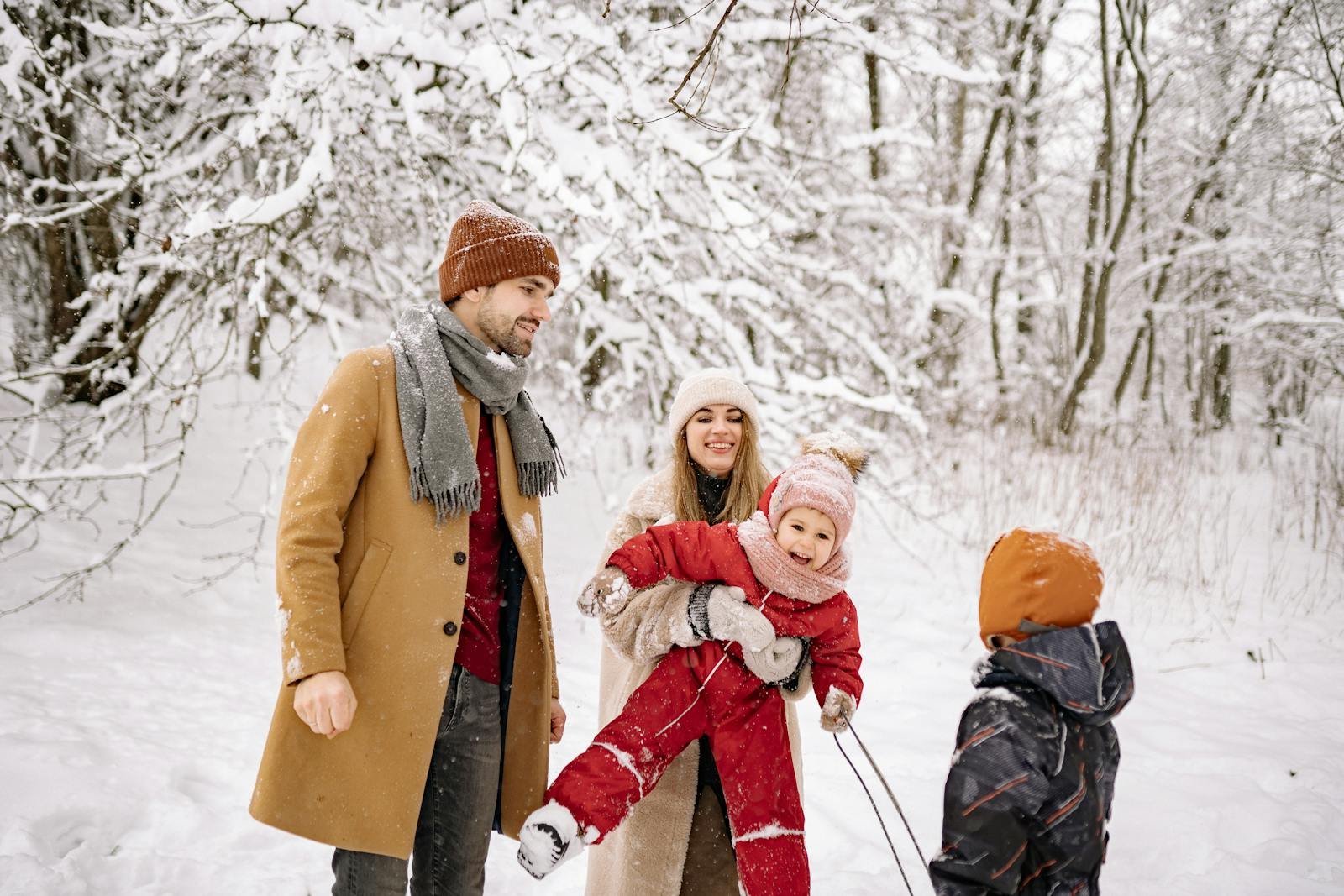 Gezin met twee kinderen in winterkleding wandelt door een besneeuwd bos
