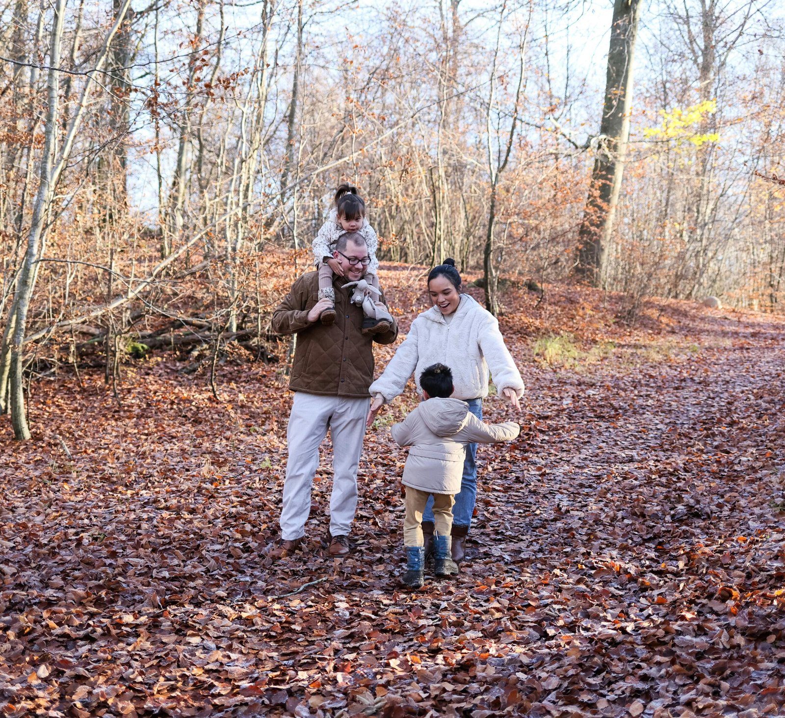 Gezin met twee kinderen wandelt door herfstbos - kindvriendelijke parken in Belgie