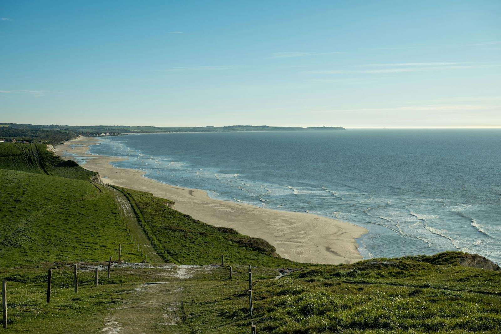 Brede zandstrand van de Côte d'Opale gezien vanaf de groene kliffen bij Escalles, Noord-Frankrijk