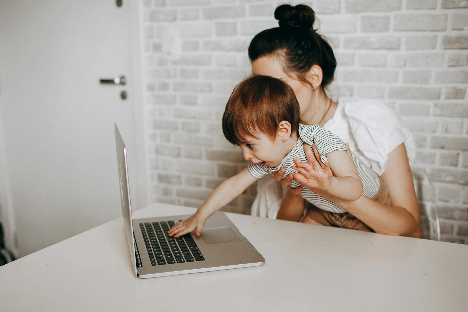 Moeder en kind boeken thuis met laptop een korting bij Center Parcs