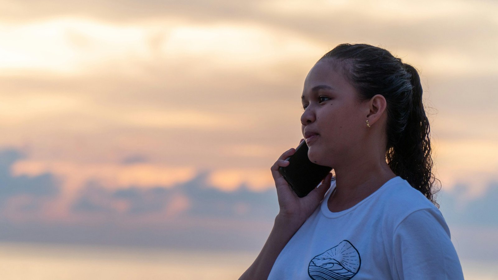 Vrouw belt met haar smartphone aan zee — illustratief beeld bij contact opnemen met Roompot Beach Resort