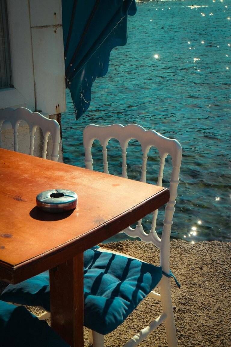 Strandterras met houten tafel en stoelen aan zee