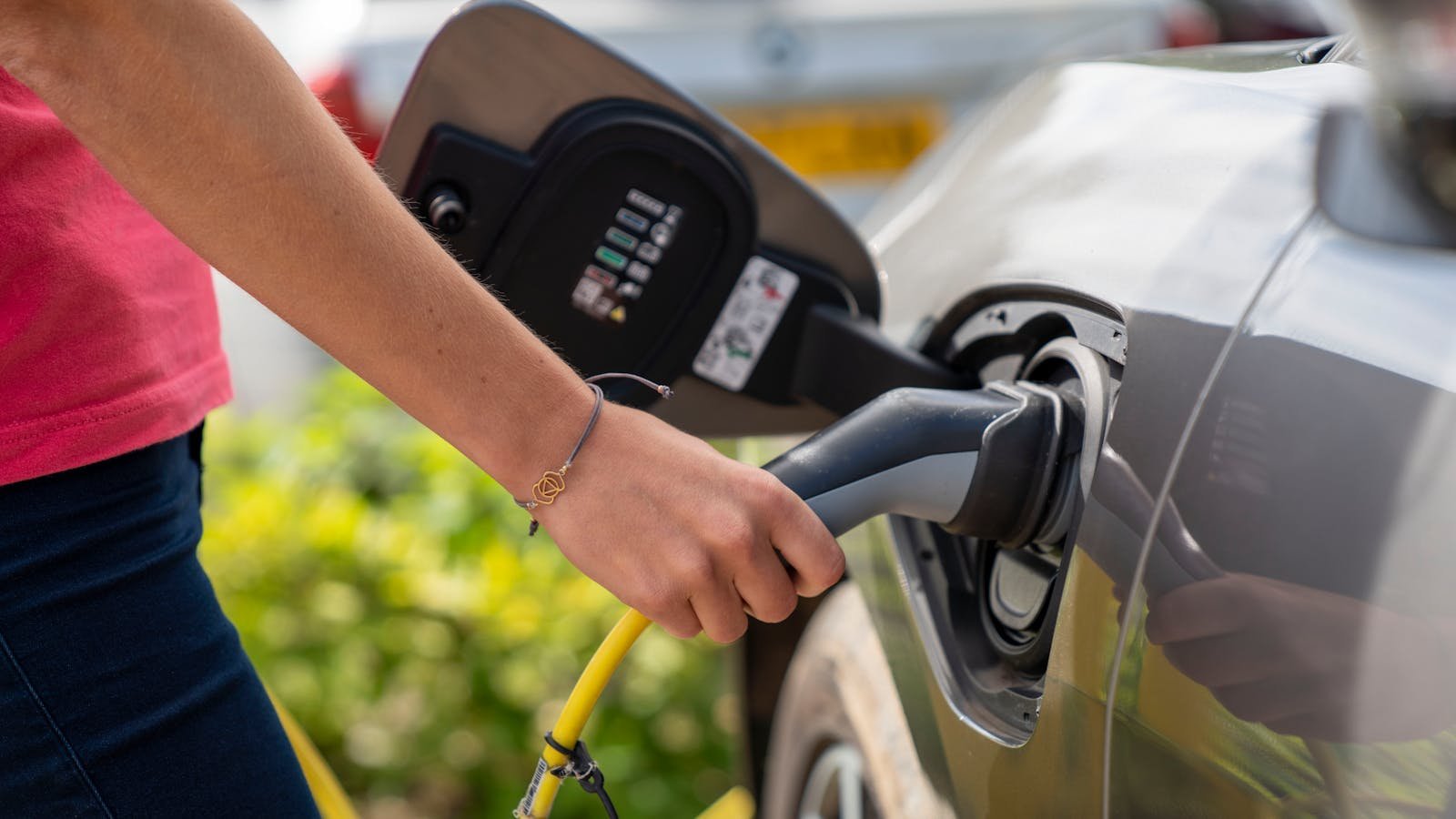 Elektrische auto wordt opgeladen aan een laadpaal in de buitenlucht
