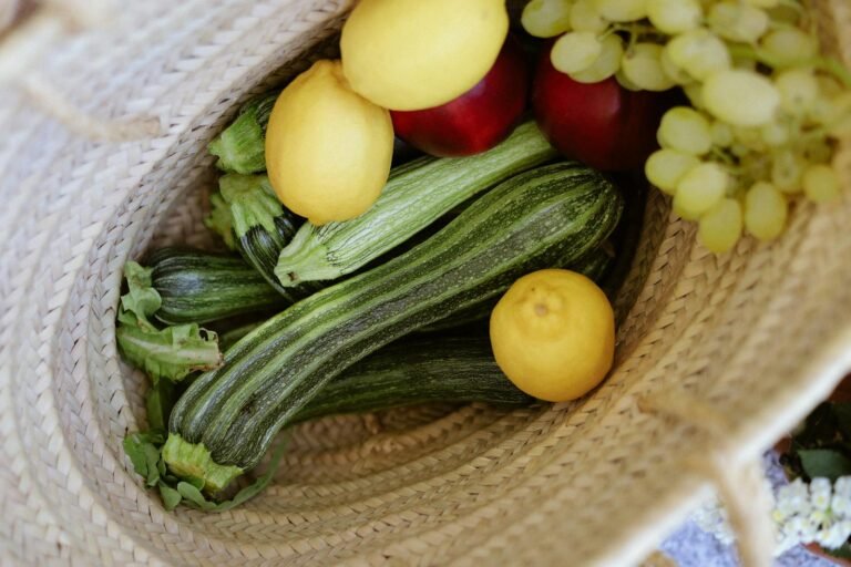 Mandje met verse groenten en fruit (courgette, citroenen, appels, druiven)