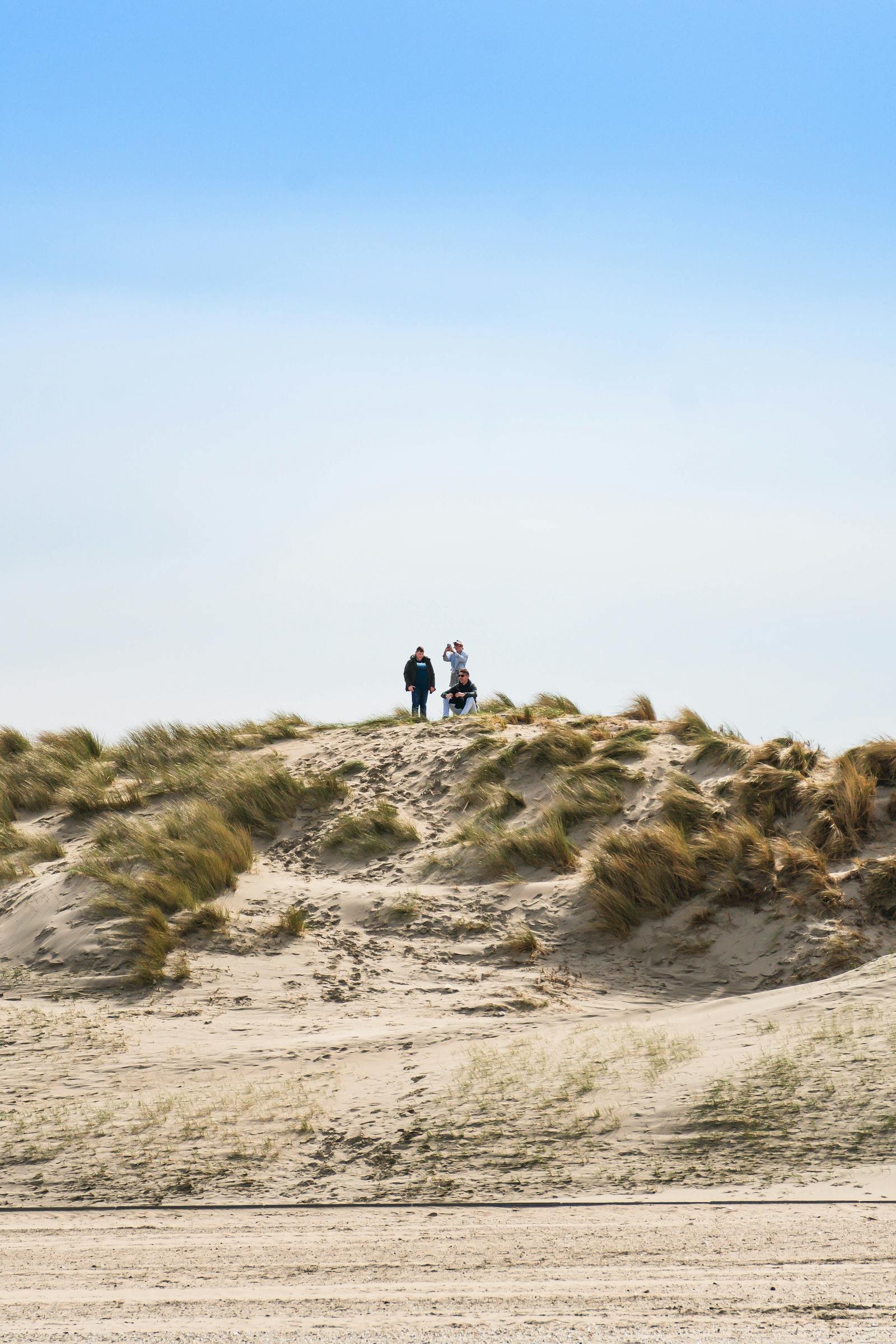 Gezin wandelt op duinen langs Noordzeestrand bij Strandpark Duynhille in Ouddorp