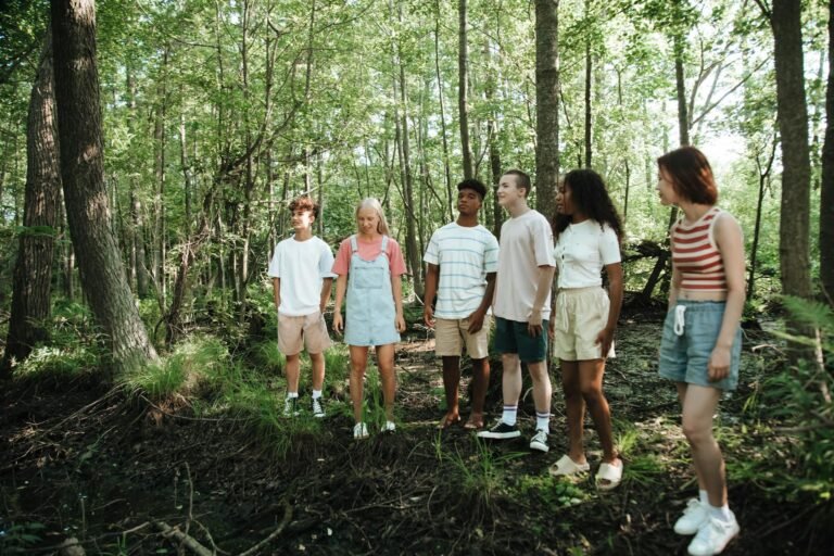 Groep tieners in een loofbos zoals je dat in de Belgische Ardennen tegenkomt
