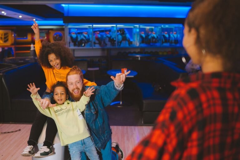 Gezin lacht en juicht tijdens het bowlen in de Action Factory van Center Parcs