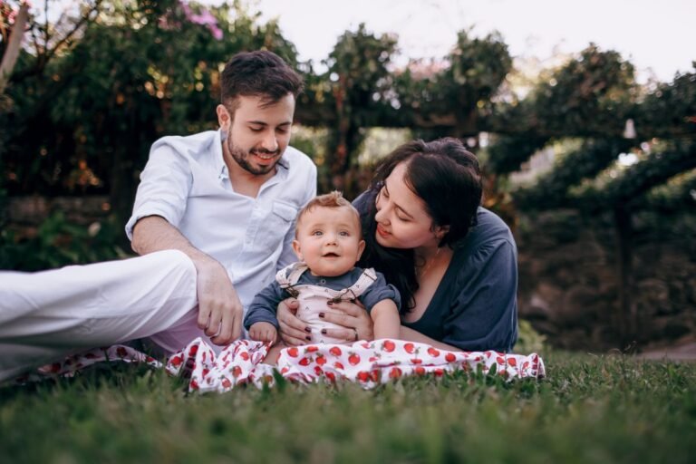 Ouders met hun baby in het gras in een groen vakantiepark