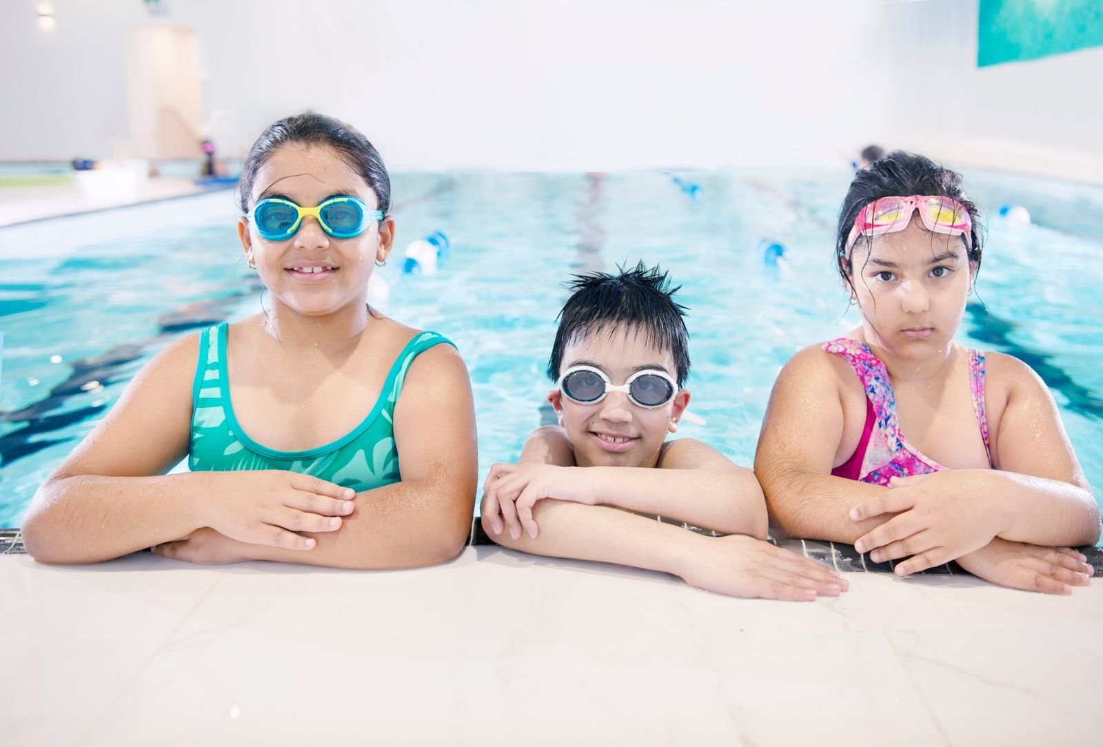Lachende kinderen aan de rand van een binnenbad tijdens een dagje zwemmen bij Center Parcs