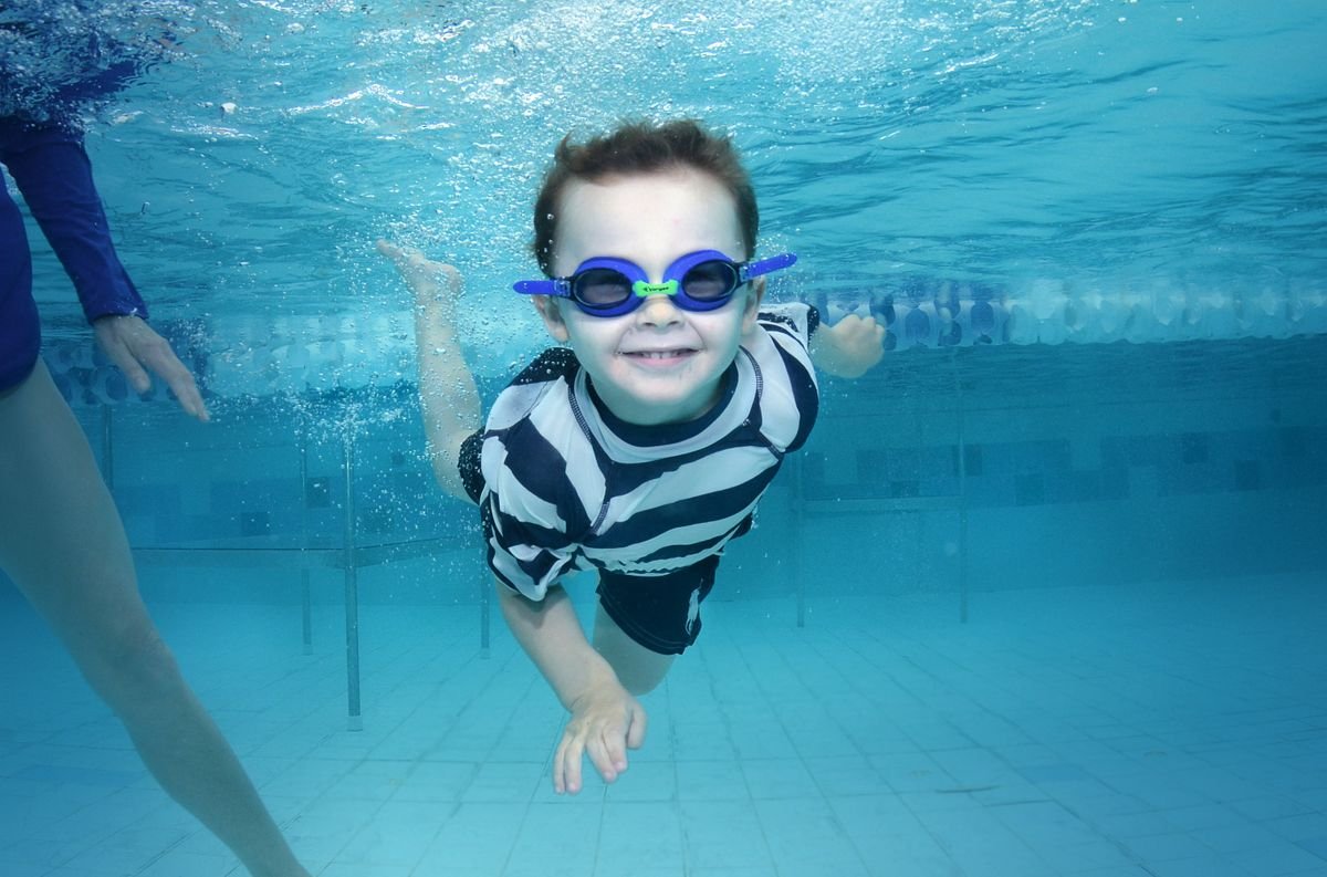 Kind zwemt onder water met een zwembril in een binnenbad tijdens een dagje zwemmen bij Center Parcs De Kempervennen