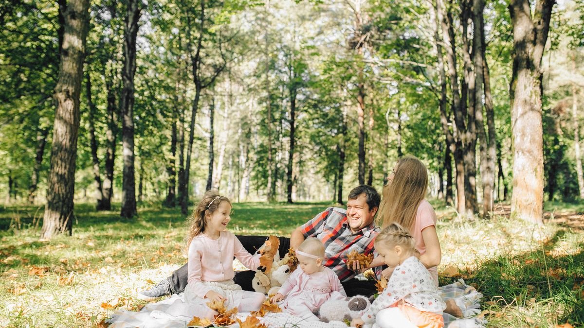 Gezin geniet van een picknick in een zonnig bos bij Center Parcs De Huttenheugte