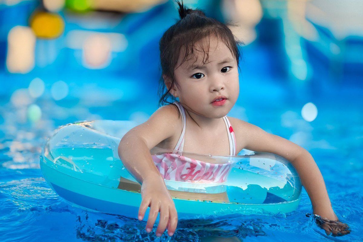 Kind zwemt met plezier in het blauwe water van Aqua Mundo Erperheide