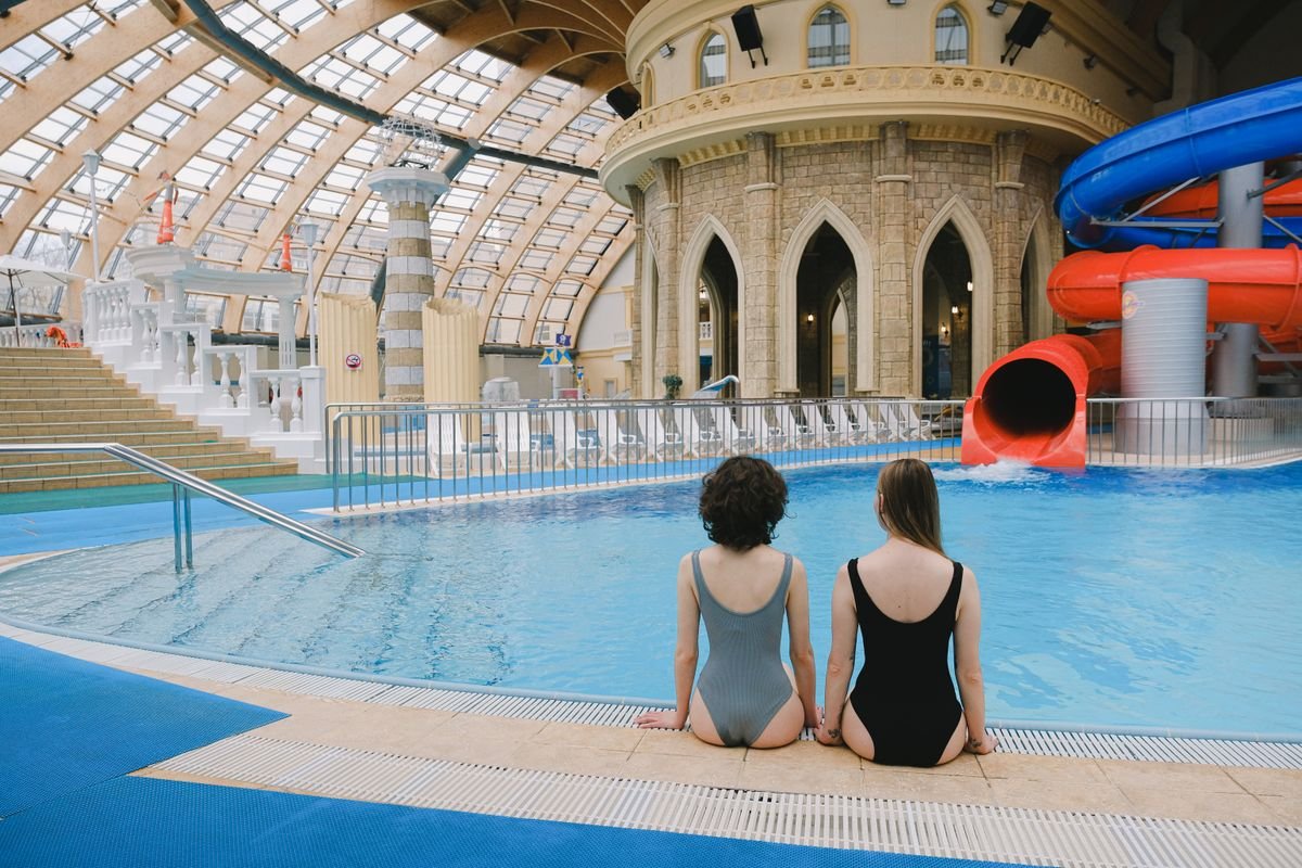 Binnenzwembad met glazen koepel en waterglijbanen zoals de Aqua Mundo van Center Parcs Port Zélande