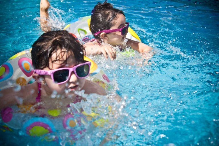 Kinderen spetteren met zwemband in een groot subtropisch zwembad