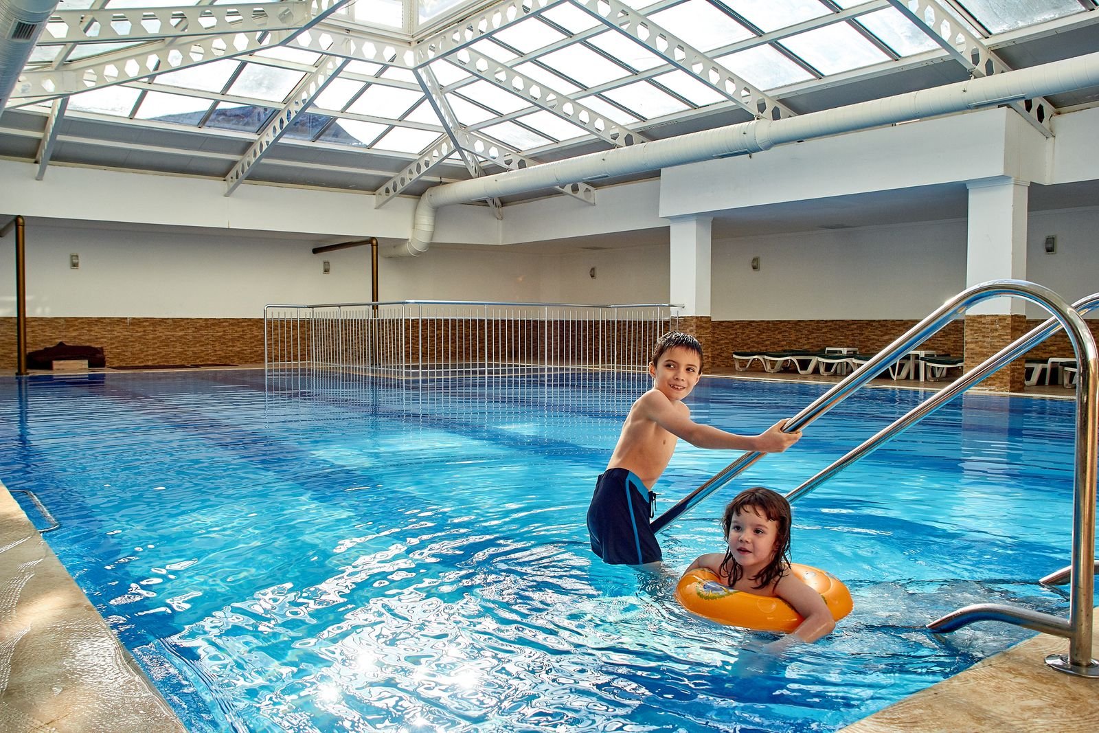 Twee kinderen zwemmen in een overdekt zwembad onder een glazen koepel - sfeer Aqua Mundo Het Meerdal